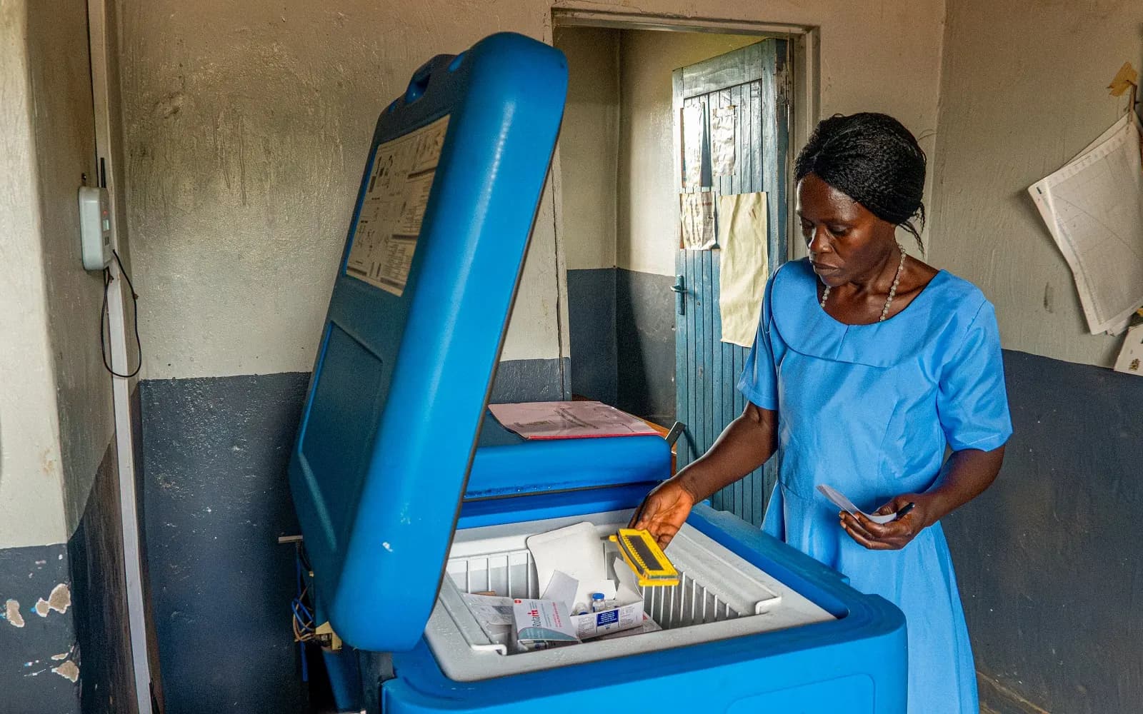 Nurse taking vaccines from a solar-powered cold-chain refrigerator