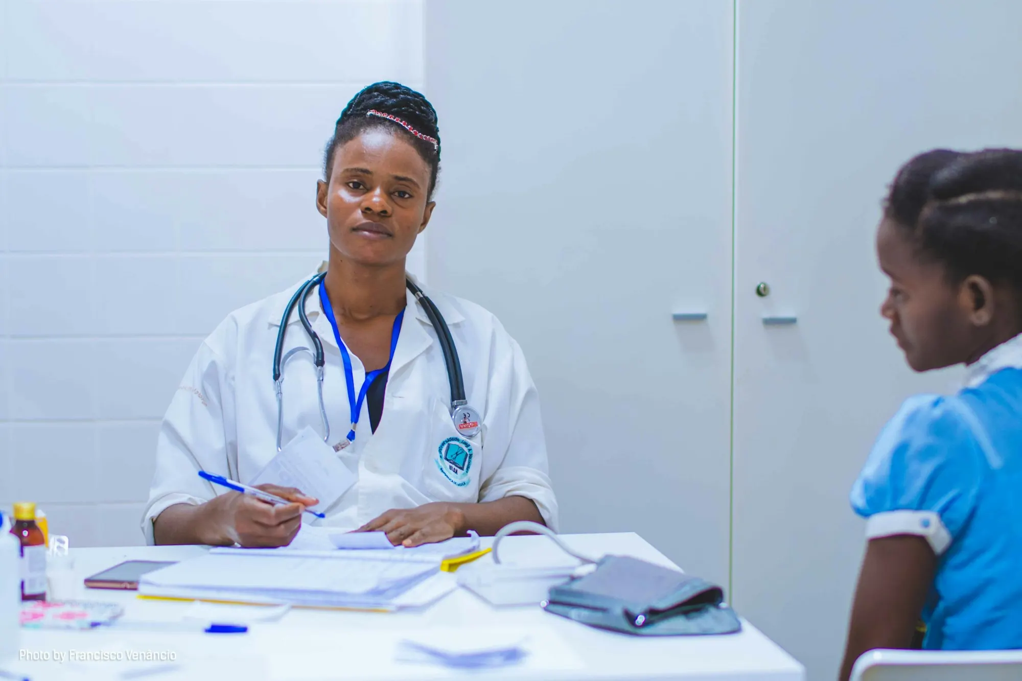 Doctor in a white coat attending to a young patient in a clinic