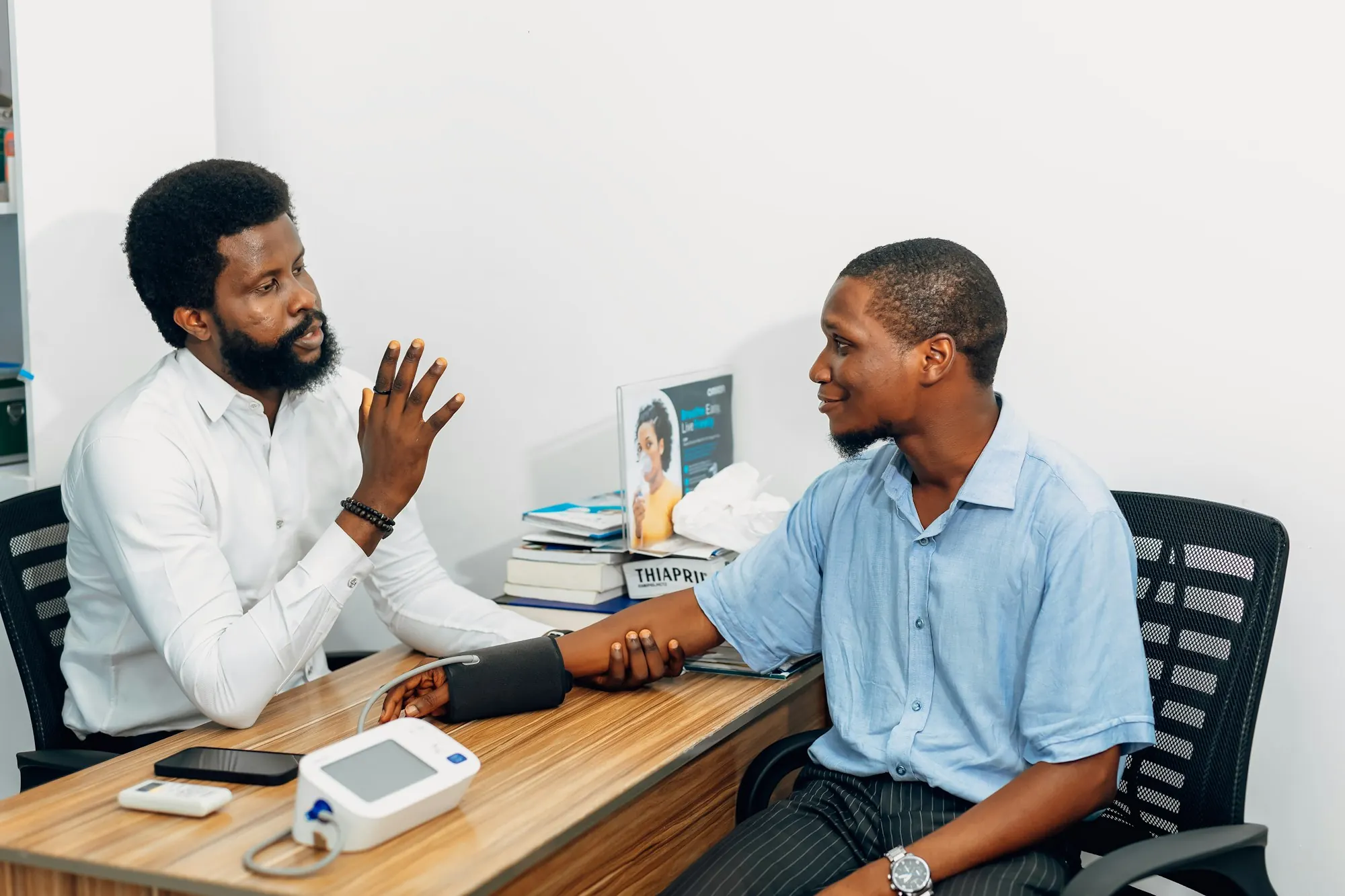 Clinician consulting with a patient across a desk