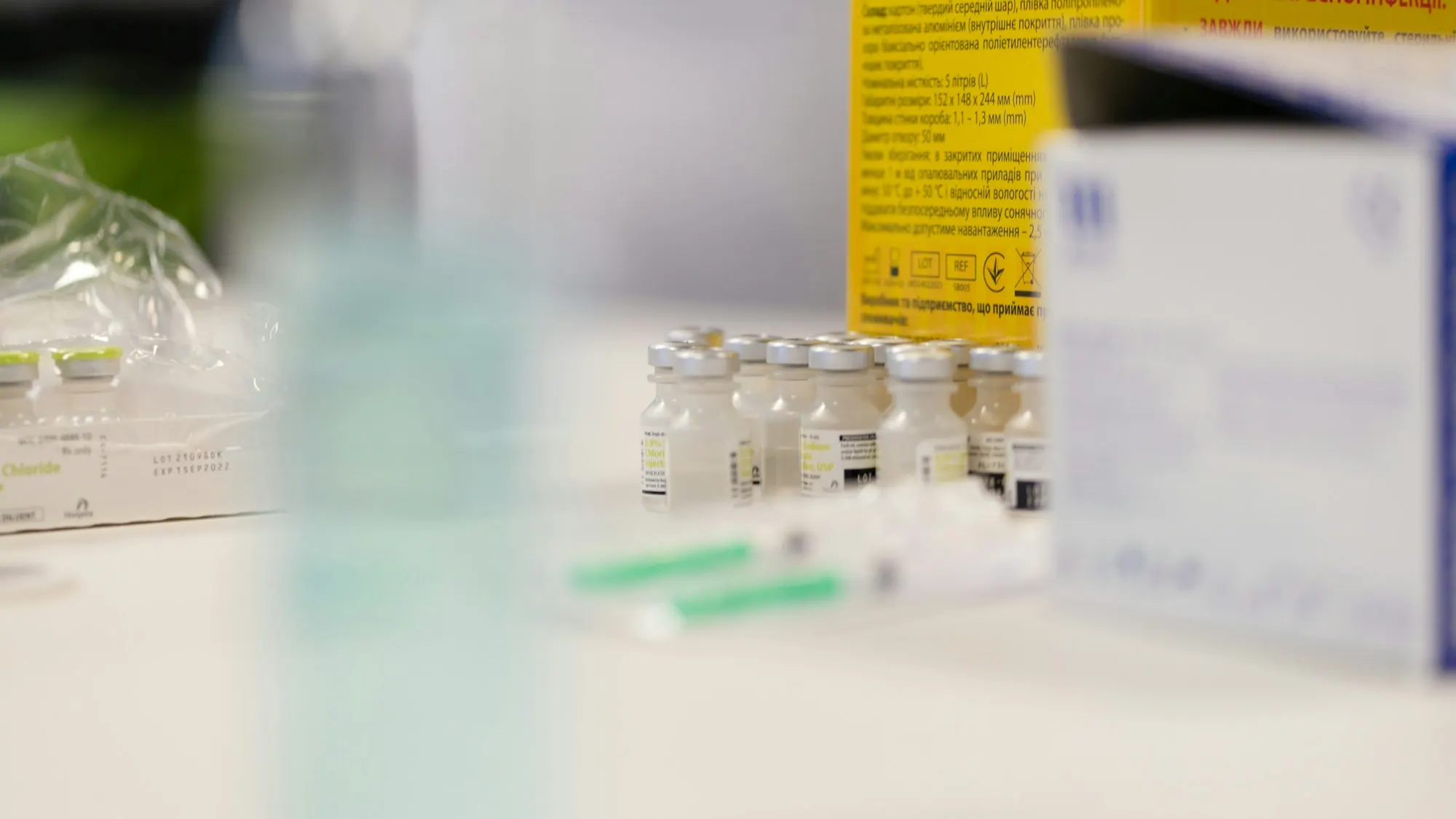 Vaccine vials and syringes prepared on a clinic counter